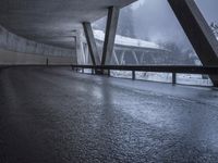 a motorcycle is going down the highway in the snow, under a bridge that goes above it