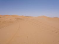 a motorcycle is in the desert looking over its body at the other side of the dune