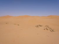 a motorcycle is in the desert looking over its body at the other side of the dune