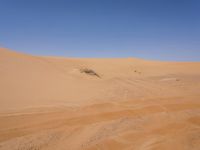 a motorcycle is in the desert looking over its body at the other side of the dune