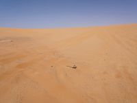 a motorcycle is in the desert looking over its body at the other side of the dune