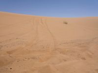 a motorcycle is in the desert looking over its body at the other side of the dune