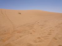 a motorcycle is in the desert looking over its body at the other side of the dune