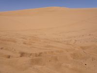 a motorcycle is in the desert looking over its body at the other side of the dune