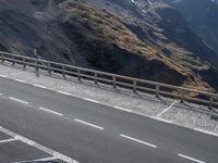 the motorcycle is traveling down the road near the mountains by itself on the side of the road