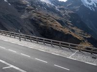 the motorcycle is traveling down the road near the mountains by itself on the side of the road