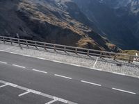 the motorcycle is traveling down the road near the mountains by itself on the side of the road