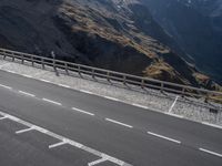 the motorcycle is traveling down the road near the mountains by itself on the side of the road