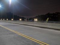 the back end of a motorcycle traveling over an empty highway at night time, near a large mountain