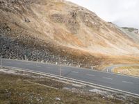 a motorcycle traveling down a winding country road in the mountains of the countryside side by side