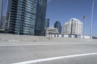 a white motorcycle is traveling on the road in a city setting next to tall buildings