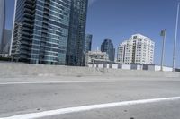 a white motorcycle is traveling on the road in a city setting next to tall buildings