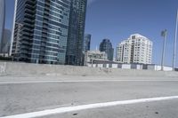 a white motorcycle is traveling on the road in a city setting next to tall buildings
