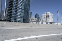 a white motorcycle is traveling on the road in a city setting next to tall buildings