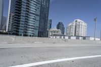 a white motorcycle is traveling on the road in a city setting next to tall buildings