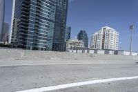 a white motorcycle is traveling on the road in a city setting next to tall buildings