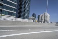 a white motorcycle is traveling on the road in a city setting next to tall buildings