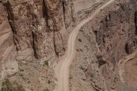 an image of a motorcyclist in the middle of a canyon setting on a winding road