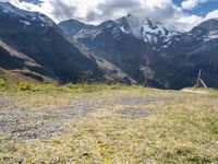 a man rides his bike up the hill next to the mountains of a mountain valley