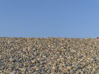 a man riding a bike on top of a mountain filled with rocks and gravel,