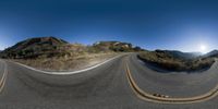 a 360 - view shows the road from a point of view with two skateboards moving along the curve of it