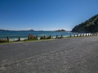 the road is empty by the ocean and mountains along the coast line it looks perfect