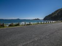 the road is empty by the ocean and mountains along the coast line it looks perfect