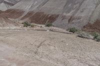 a man in yellow shirt riding on a motorcycle in the mountains, on a dirt road