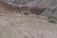 a man in yellow shirt riding on a motorcycle in the mountains, on a dirt road