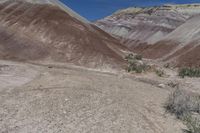 a man in yellow shirt riding on a motorcycle in the mountains, on a dirt road