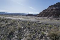 a motorcycle is parked at the edge of the road in the desert area of an area that is very large and steep