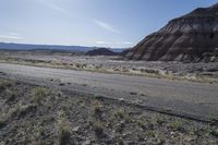 a motorcycle is parked at the edge of the road in the desert area of an area that is very large and steep