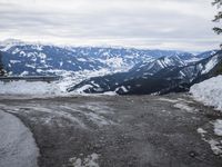 a large open road with lots of snow on the top and mountains in the background