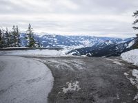 a large open road with lots of snow on the top and mountains in the background