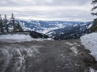 a large open road with lots of snow on the top and mountains in the background