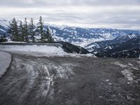 a large open road with lots of snow on the top and mountains in the background