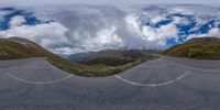 a 360 - ball panoramic photo of an empty road in the mountains on a cloudy day