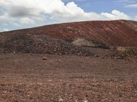 a large pile of dirt on top of a dirt covered field next to some trees