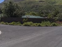 a stop sign and street in a residential neighborhood near mountains are seen here, with a house on top