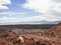 a person is riding their motorcycle up the side of a mountain above an arid area