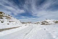 a person in the snow with skis looking at some big rocks and a hill