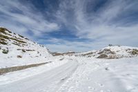 a person in the snow with skis looking at some big rocks and a hill