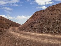 dirt path that goes along a very rough hill of rocks and gravels from the ground