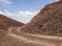 dirt path that goes along a very rough hill of rocks and gravels from the ground