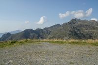 a motorcycle parked on a small mountain side road near mountains with no cars driving on it