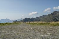 a motorcycle parked on a small mountain side road near mountains with no cars driving on it