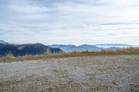 a person standing on the side of a hill watching mountains and lake from high up