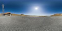 a panorama camera photograph of the road with a pole in the distance and mountains in the background