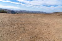 this is an image of some dirt and mountains, and the sky has just gone to full color