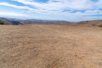 this is an image of some dirt and mountains, and the sky has just gone to full color